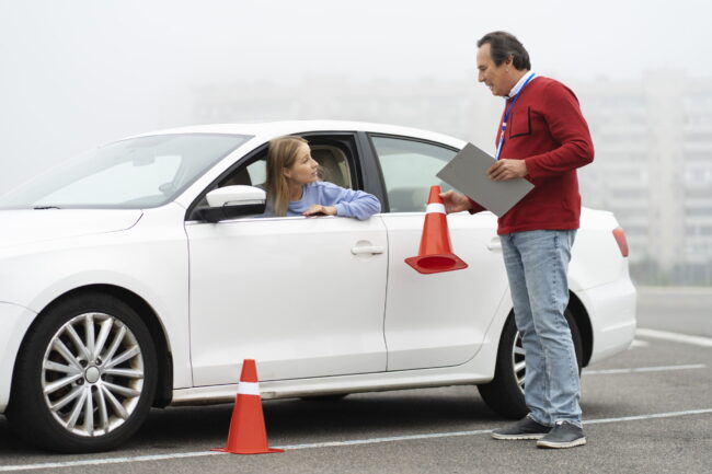 recuperar puntos del carnet de conducir en Valencia - profesor explicando en coche rojo