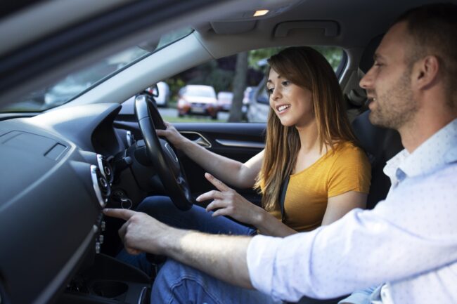 autoescuela para sacar carnet b en valencia - hombre guiando a chica